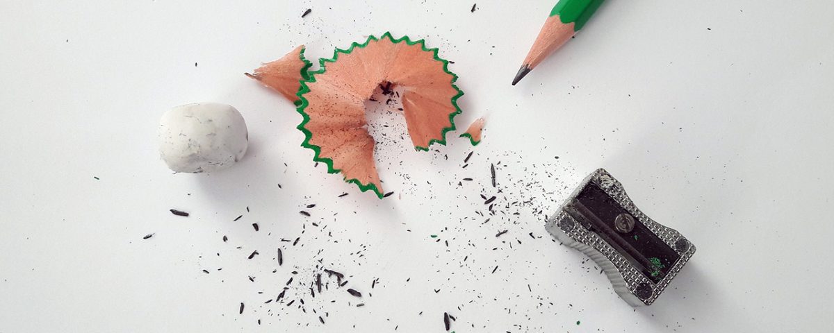 Pencil, sharpener, and eraser on white paper