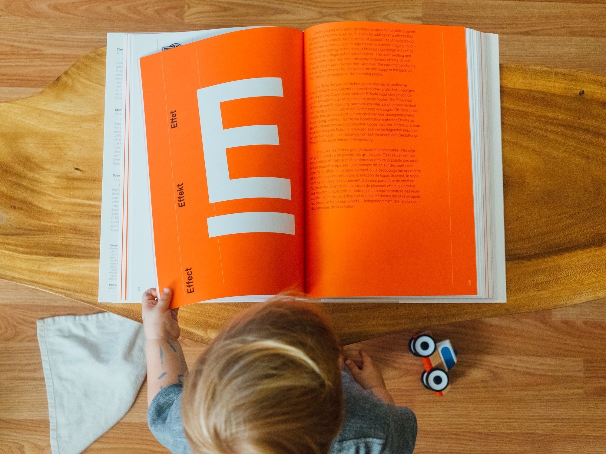 child looking through a book about graphic design